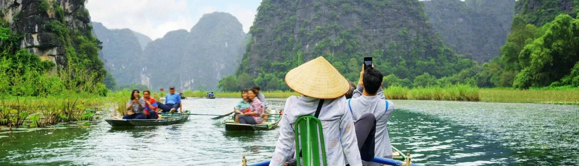 Tourists traveling in boats along the Ngo Dong River at the Tam Coc portion, Ninh Binh Province, Vietnam — Shutterstock