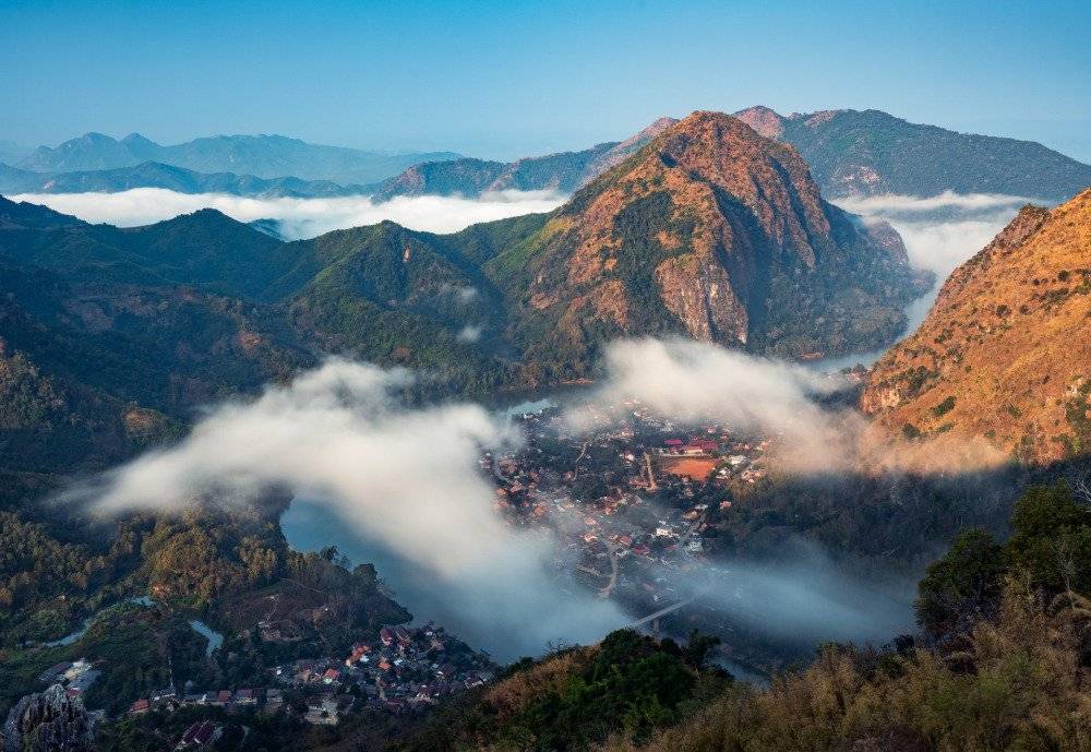 A panoramic view from Nong Khiaw overlooking karst mountains and a river.
